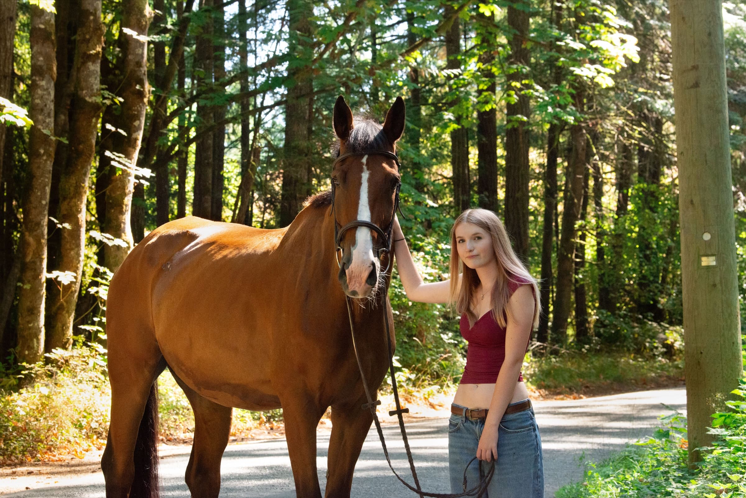 Charlotte with her bay horse on a forest road on Vancouver Island